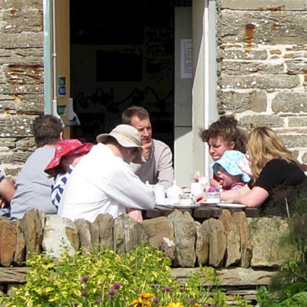 People eating outside the heritage Centre on a picnic bench