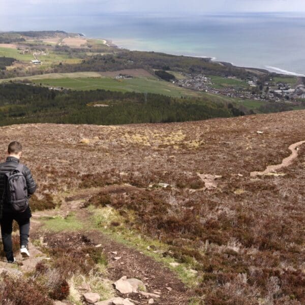 A man behins his descent down Ben Bhraggie, heading back towards Golspie