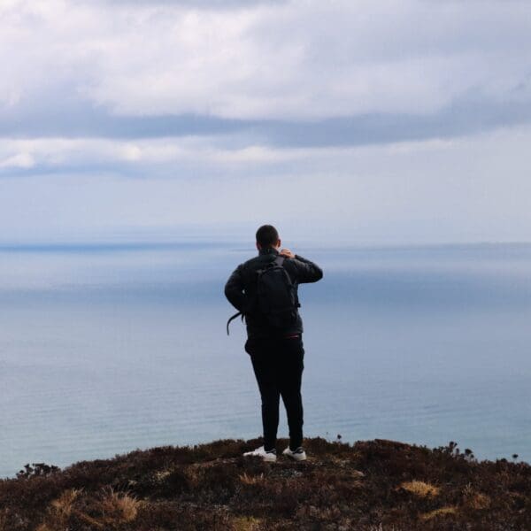 A man stands on top of Ben Bhraggie looking out to sea, near Golspie, Sutherland
