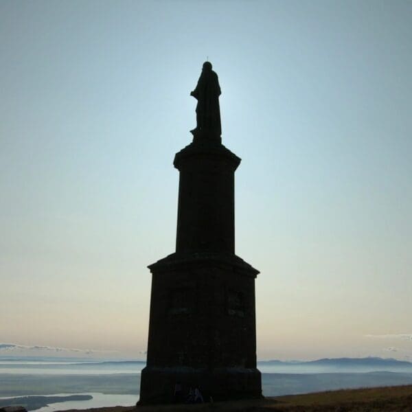 The Mannie, statue of the Duke of Sutherland, backlit by the sun so only it's silhouette is visible