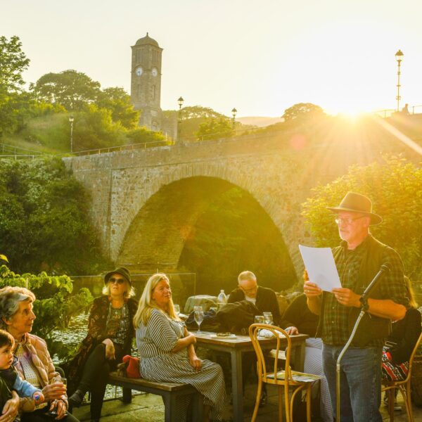 A man stands talking to a crowd at Timespan, Helmsdale, Sutherland