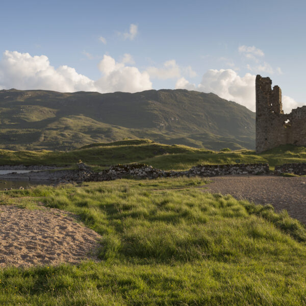 Ardvreck Castle in loch Assynt with the sandy banks of the Loch in the foreground