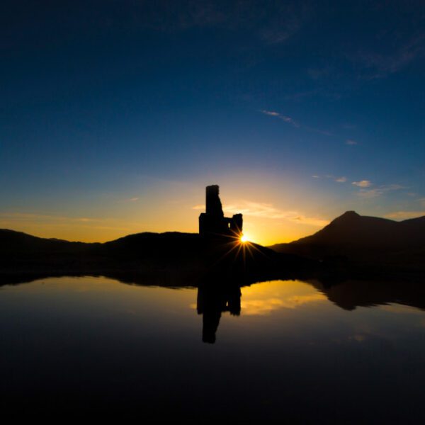 Ardvreck Castle in the distance, viewed across Loch Assynt at sunset